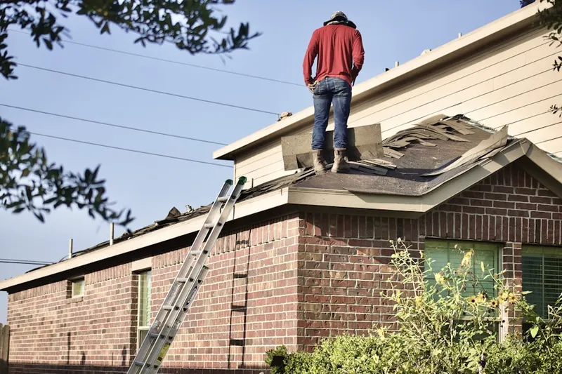 Professional roofer working on a residential roof in Ladue